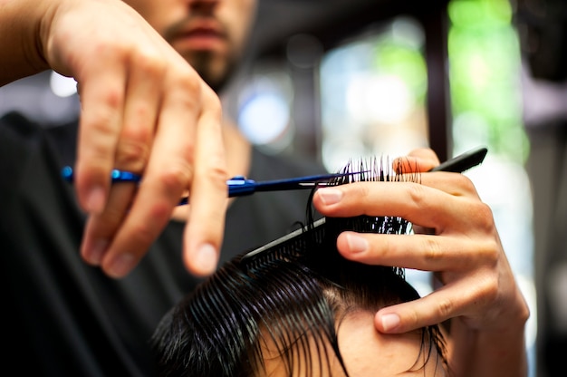 Primer plano de cabello mojado recibiendo un corte de pelo