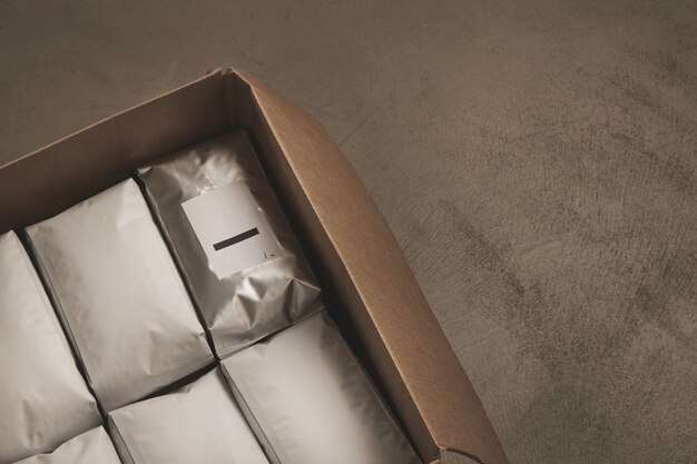 Primer plano de una caja de cartón grande abierta llena de paquetes blancos