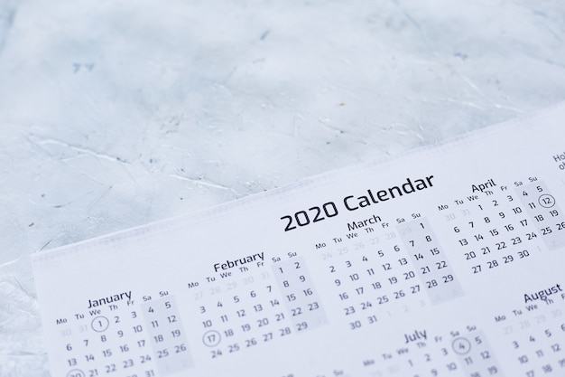 Primer plano de un calendario 2020 sobre una superficie con textura blanca
