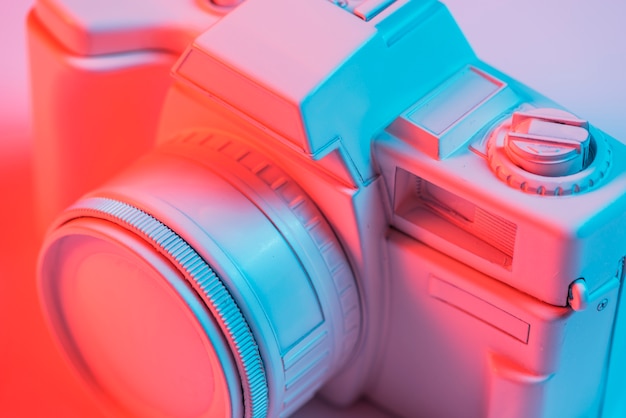 Foto gratuita primer plano de la cámara rosa retro con luz azul
