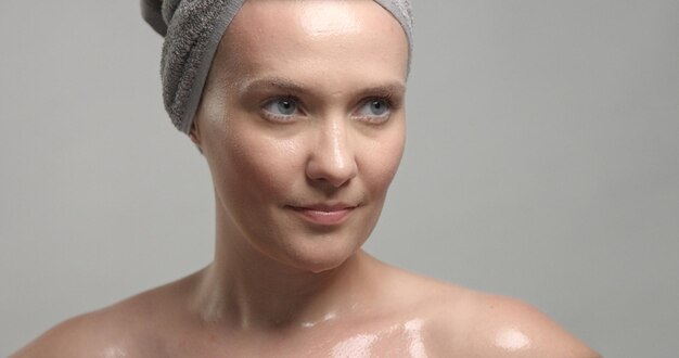 Primer plano de la cara de la mujer con la piel húmeda con gotas de agua sobre ella Concepto de piel hidratante
