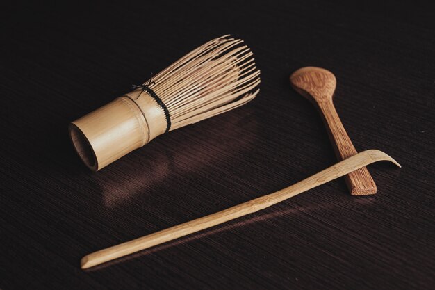 Primer plano de un cepillo de cocina con cucharas de madera sobre un fondo negro