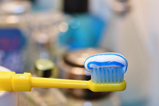 Primer plano de cepillo de dientes amarillo con pasta