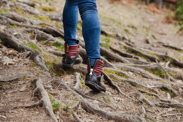 Primer plano de chica caminando sobre la tierra con raíces