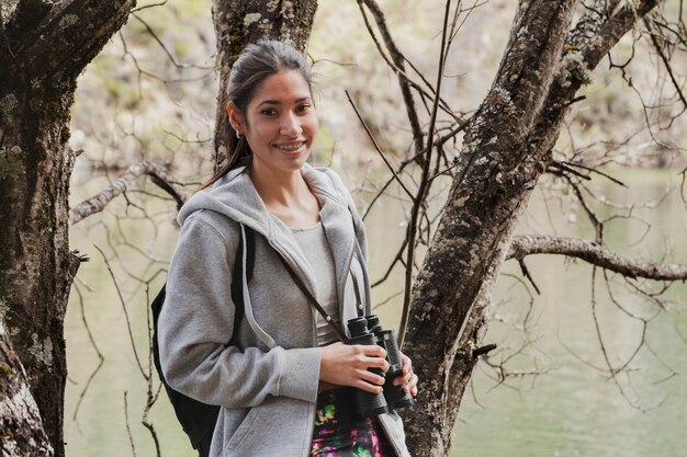 Primer plano de chica morena feliz con prismáticos