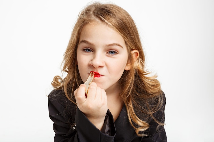 Foto gratuito primer plano de chica rubia divertida puttng en lápiz labial rojo