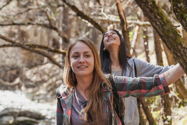 Foto gratuita primer plano de chica sonriendo con su amiga detrás