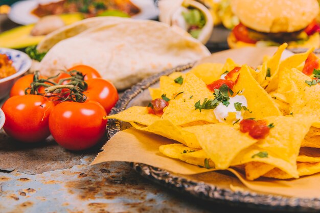 Primer plano de chips de nacho mexicano amarillo con tomate cherry