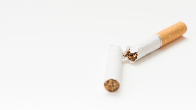 Primer plano de cigarrillo roto sobre fondo blanco