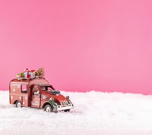 Primer plano de un coche de juguete para la decoración navideña en la nieve