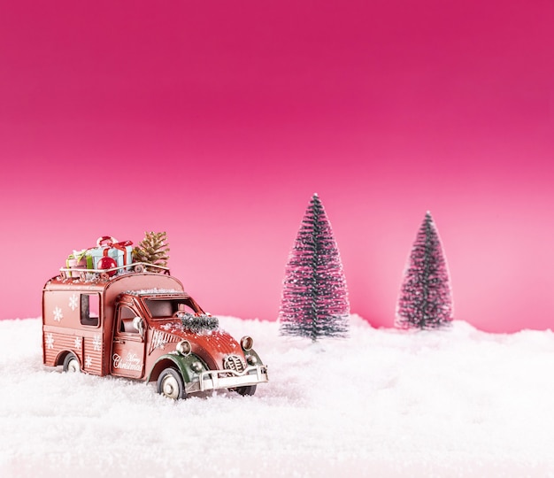 Primer plano de un coche de juguete para la decoración navideña en la nieve
