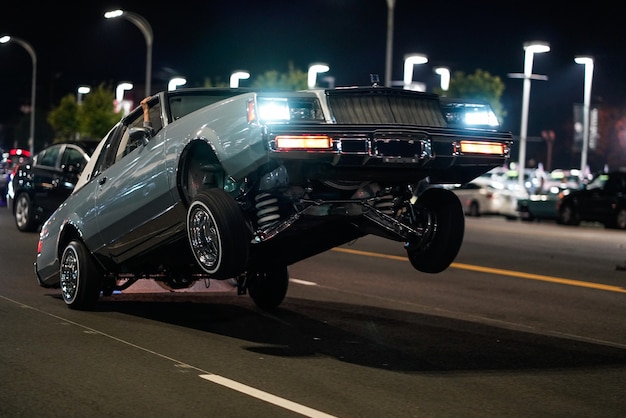 Foto gratuita primer plano de un coche retro con sólo las ruedas traseras en el suelo en una calle por la noche