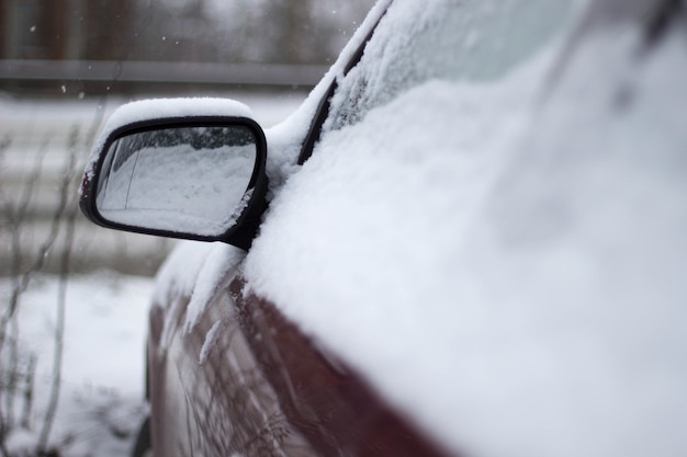 Primer plano de un coche rojo cubierto de nieve