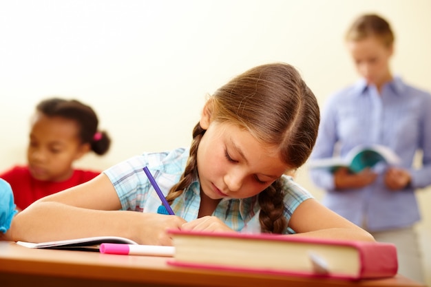 Primer plano de colegiala sosteniendo un lápiz morado