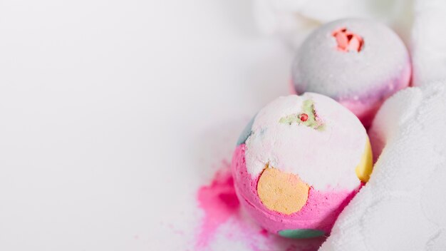 Primer plano de coloridas bombas de baño y servilleta sobre fondo blanco