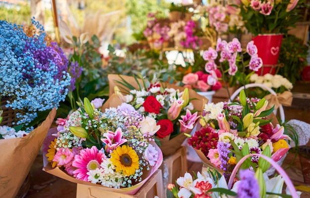 Primer plano de coloridos ramos de flores en contenedores en una tienda al aire libre