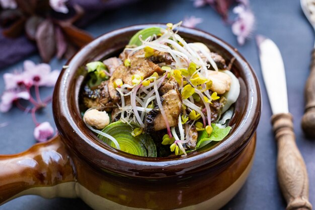 Primer plano de una comida vegana con champiñones, cebollas, zanahorias y puerros