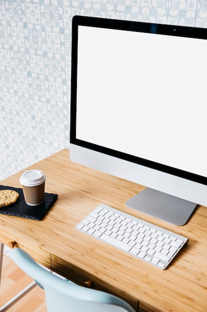 Primer plano de la computadora y el teclado en el escritorio de madera