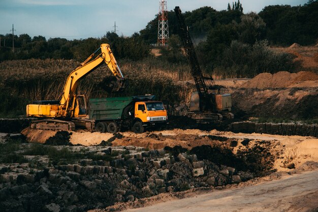 Primer plano de una construcción en curso con orugas y una excavadora en una tierra abandonada