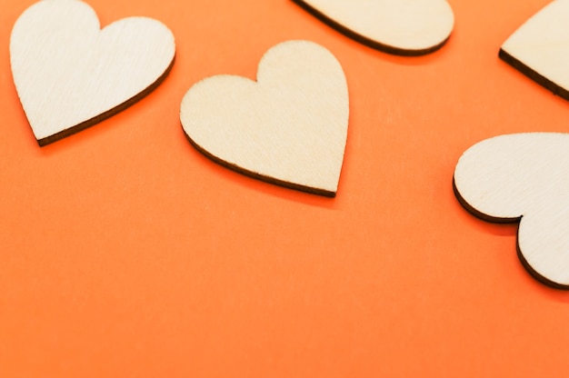 Primer plano de los corazones con forma de madera sobre la superficie naranja - espacio para texto