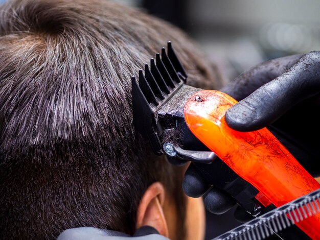 Primer plano de corte de pelo naranja trimmer