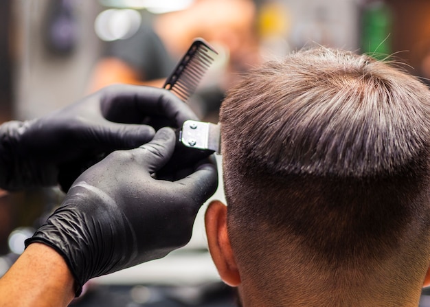 Primer plano de un corte de pelo con recortadora desde atrás