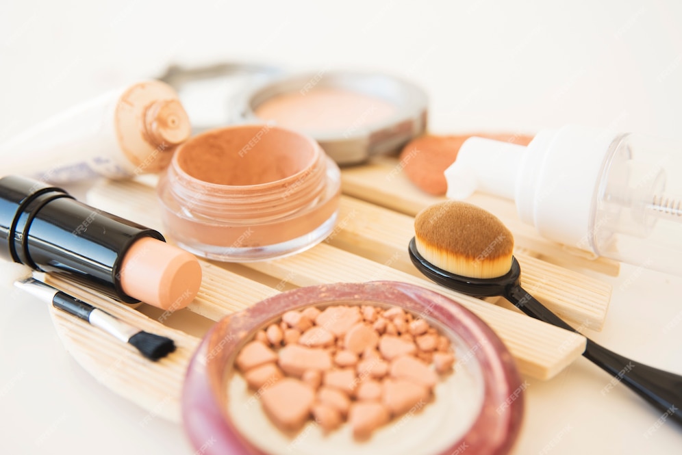 Foto gratuita primer plano de los cosméticos de una mujer utiliza polvo de maquillaje; cepillo; pintalabios y crema