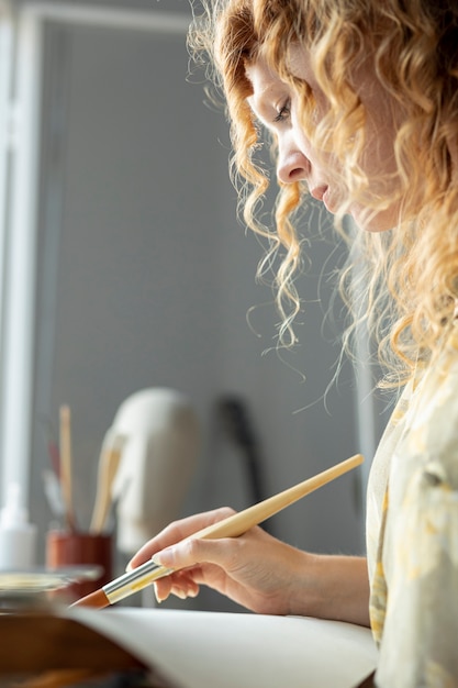 Primer plano creativo mujer pintando en casa