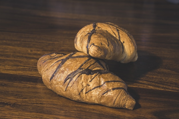 Primer plano de croissants de chocolate sobre una superficie de madera