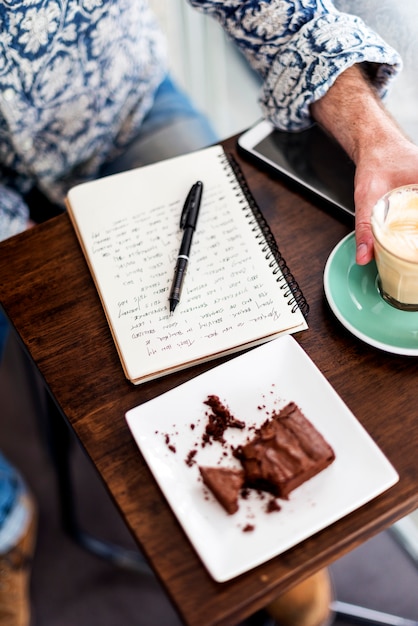 Primer plano del cuaderno de viaje en la mesa de madera en el café