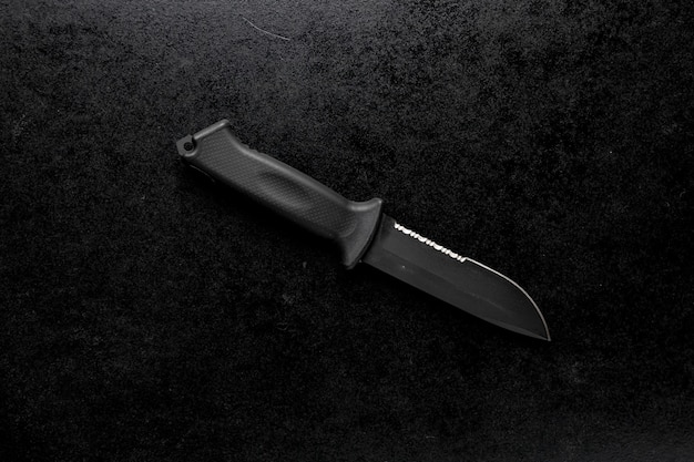 Primer plano de un cuchillo afilado fijo sobre un negro