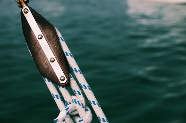 Primer plano de cuerdas apretadas en un barco de pesca con un mar borroso