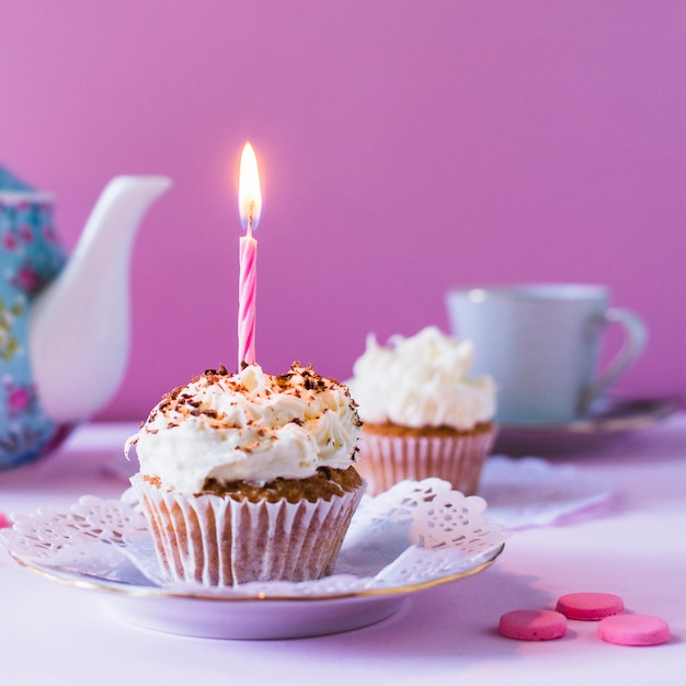 Primer plano de cupcake con vela encendida en cumpleaños