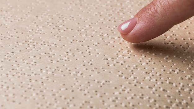 Primer plano dedo tocando la página braille