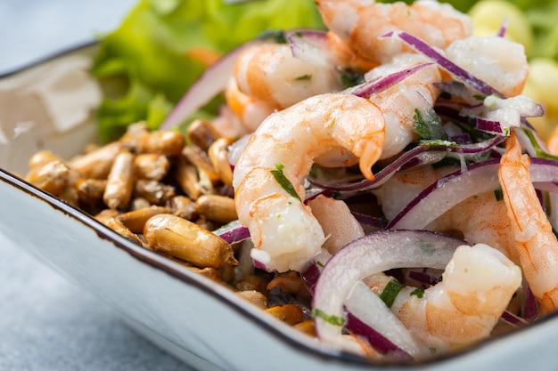 Primer plano de una deliciosa ensalada con mariscos y verduras en un recipiente sobre la mesa