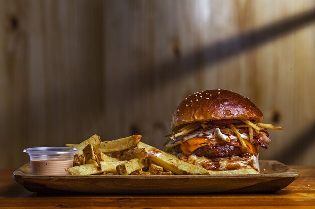 Primer plano de una deliciosa hamburguesa con papas fritas en la mesa