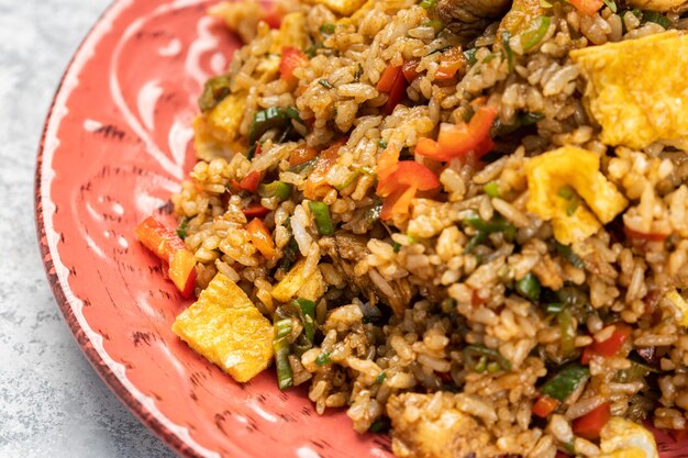 Primer plano de un delicioso arroz cocido con verduras y salsa en un plato sobre la mesa