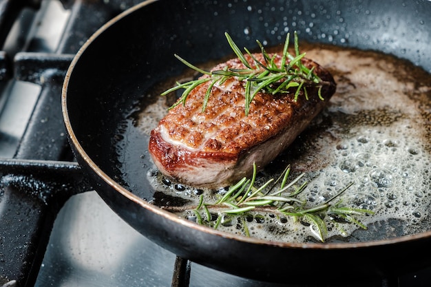 Primer plano de delicioso filete de pechuga de pato frito en una sartén