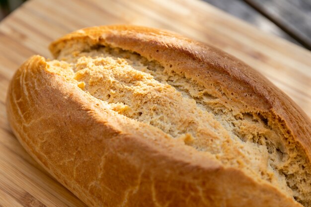 Primer plano de delicioso pan de masa fermentada sobre una superficie de madera bajo la luz del sol