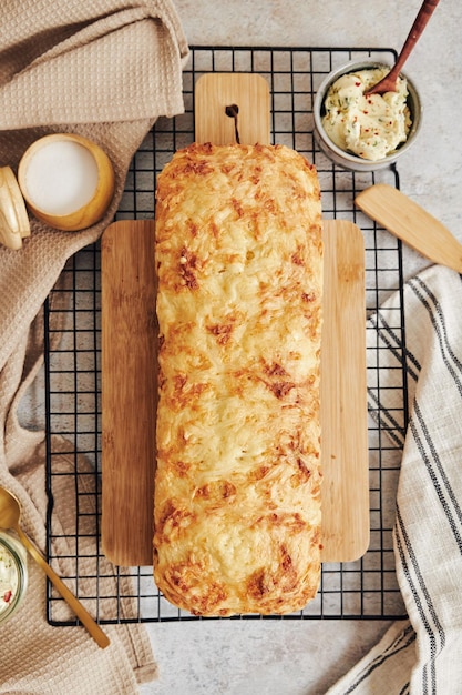 Primer plano de delicioso pan de queso con mantequilla de hierbas sobre una mesa blanca