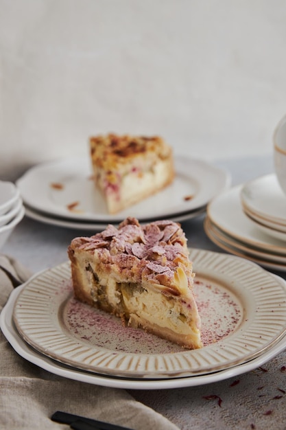 Primer plano de un delicioso pastel de queso de ruibarbo en un plato sobre una mesa blanca