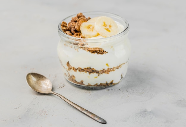 Primer plano delicioso yogurt con granola y plátano