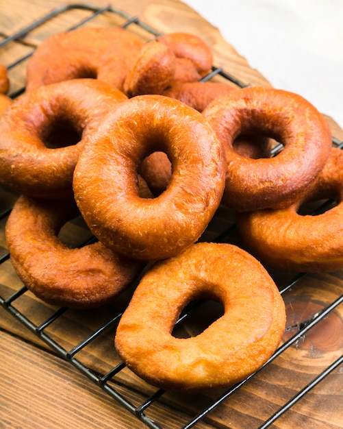 Primer plano de deliciosos donuts marrones en bandeja metálica sobre mostrador