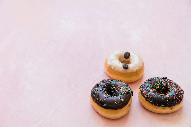 Primer plano de deliciosos donuts sobre fondo rosa