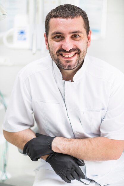 Primer plano de un dentista masculino feliz mirando a cámara