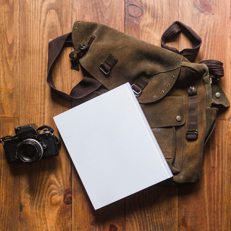 Foto gratuito primer plano de diario y bolsa con cámara en escritorio de madera
