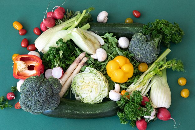 Primer plano diferentes verduras brillantes sobre un fondo verde plano lay