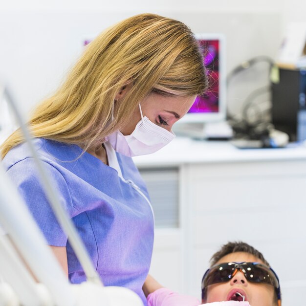 Primer plano de una doctora revisando los dientes del niño
