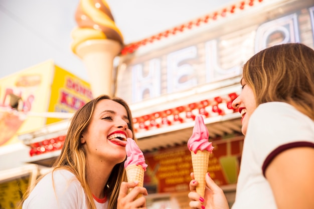 Primer plano de dos amigas felices comiendo un helado