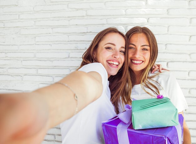 Primer plano de dos amigas felices con regalos de cumpleaños